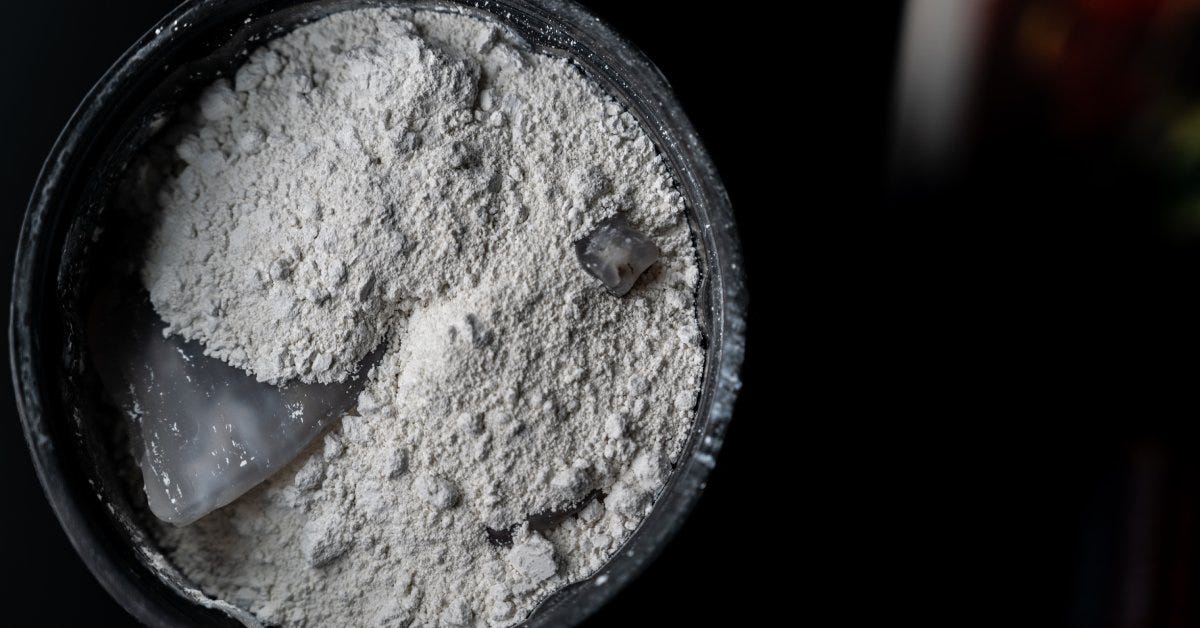 A rubber barrel with grey grit and two polished stones visible inside it during the final stage of rock tumbling.