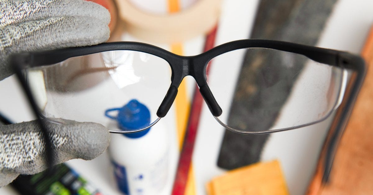 Close-up of a small circular diamond blade hanging from a thin copper wire inside a room with a white and blue background.